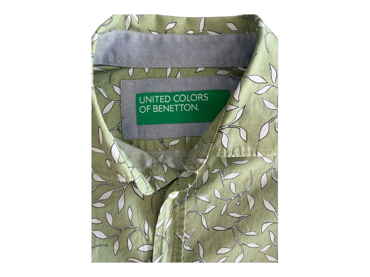 Zbliżenie kołnierzyka i zielonej metki United Colors of Benetton na koszuli we wzór listków
