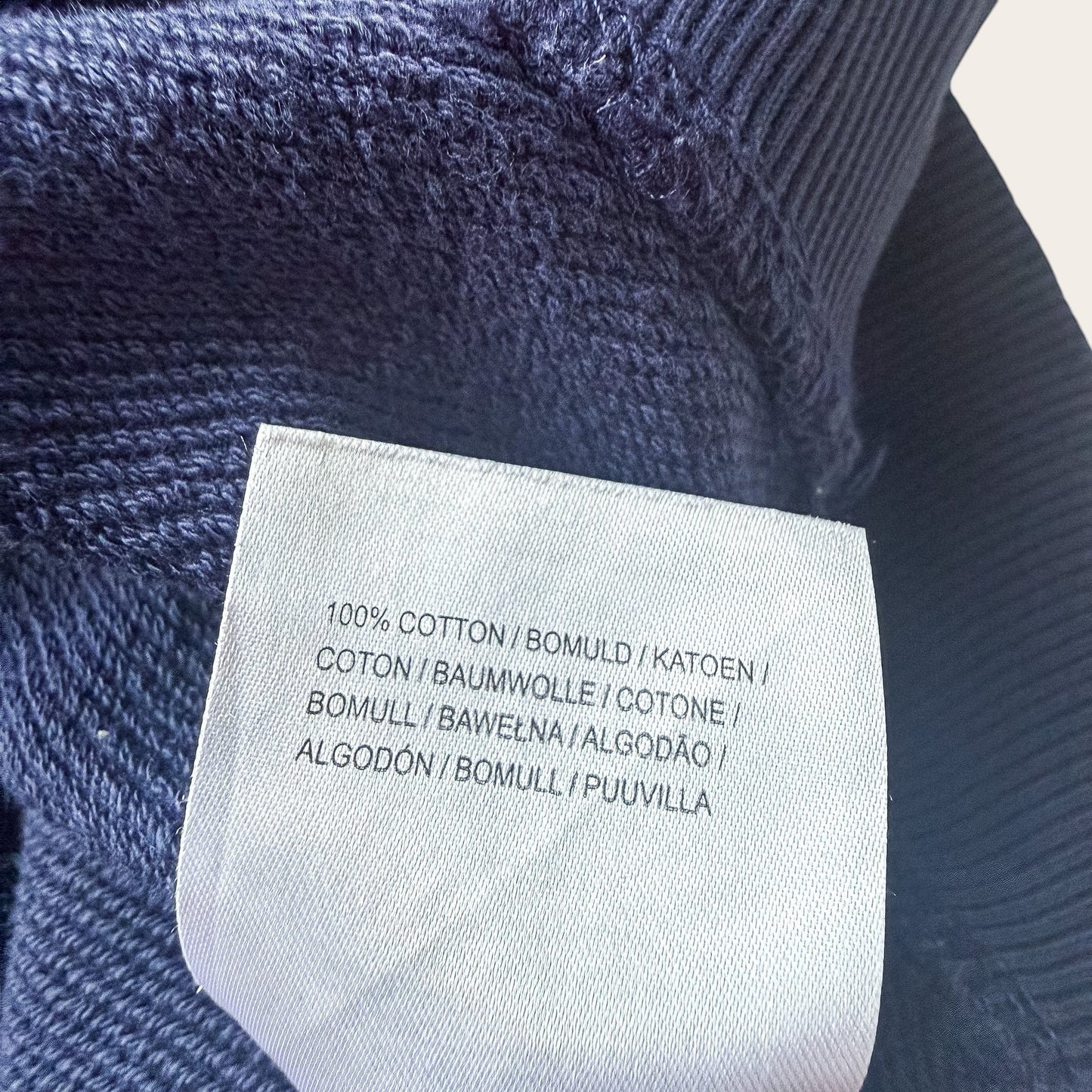 Metka wewnętrzna bluzy TrickandChic Lyle&Scott potwierdzająca skład 100% bawełny w kolorze granatowym