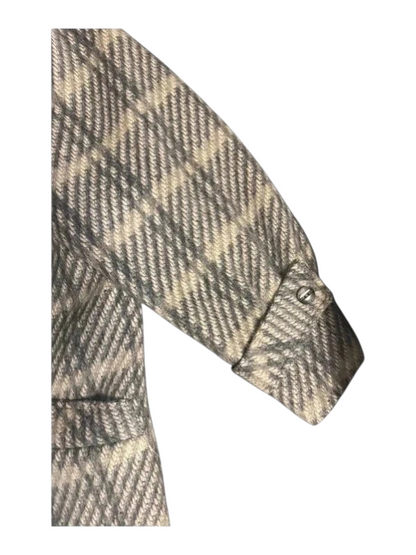 Zbliżenie rękawa płaszcza w kratę z szerokim mankietem i paskiem zapinanym na guzik