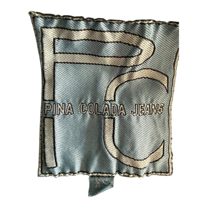Metka odzieżowa marki Pina Colada Jeans z logo PC na jasnoniebieskim tle w sklepie TrickandChic