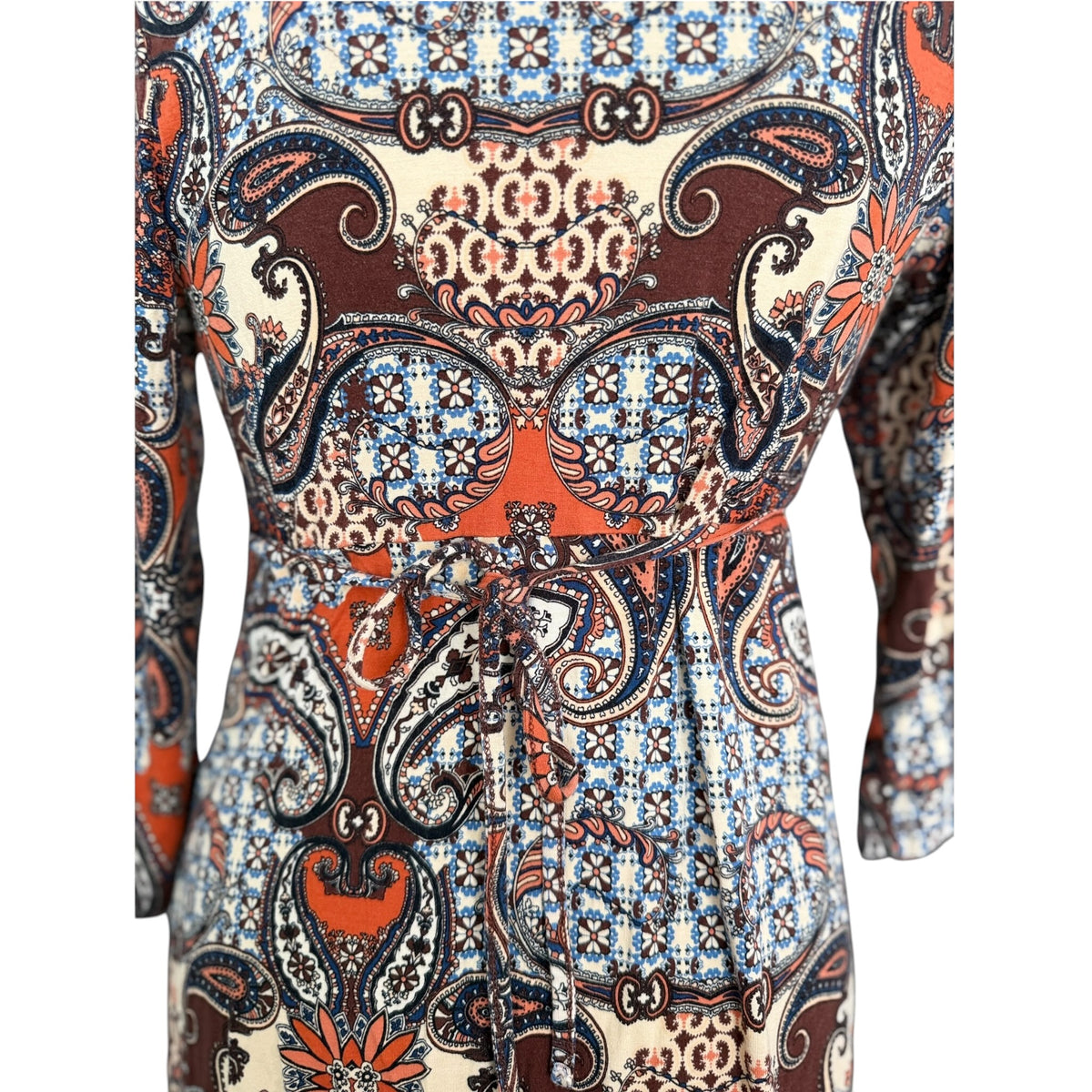 Zbliżenie wiązania w talii i wzoru paisley z kwiatowymi ornamentami na sukience boho