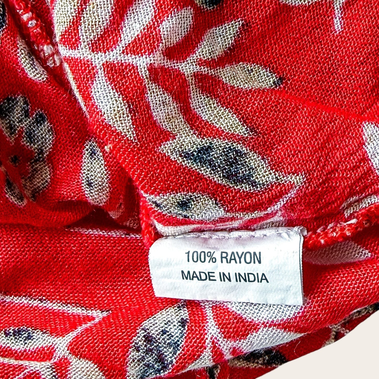 Metka ze składem 100% rayon na czerwonej zwiewnej bluzce TrickandChic z roślinnym wzorem