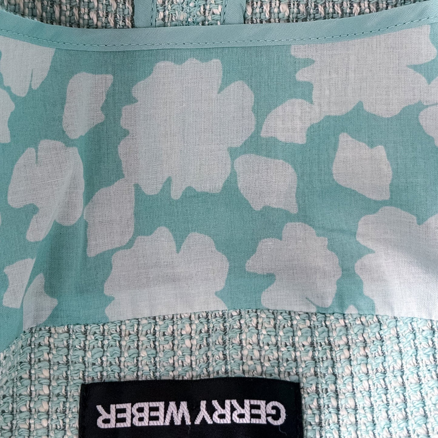 Wnętrze żakietu TrickandChic Gerry Weber z seledynową podszewką w białe kwiaty i metką marki