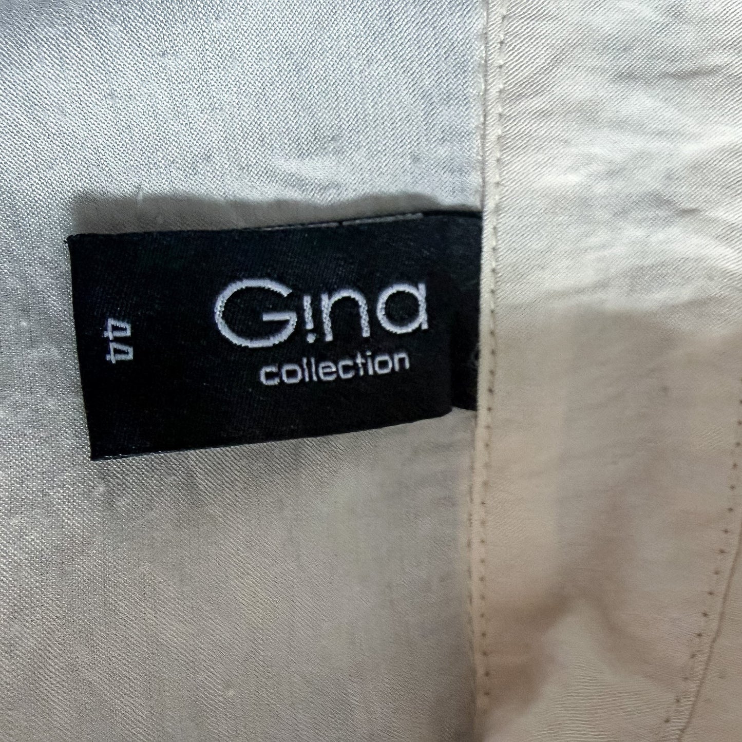 Metka marki Gina Collection z rozmiarem 44 na kremowej satynowej koszuli od TrickandChic