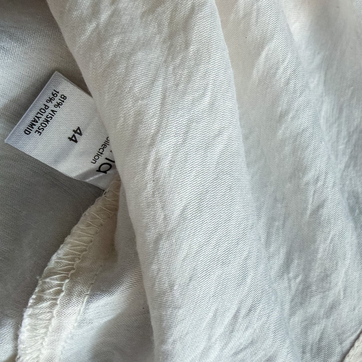Metka z informacją o składzie materiału kremowej koszuli oversize marki TrickandChic
