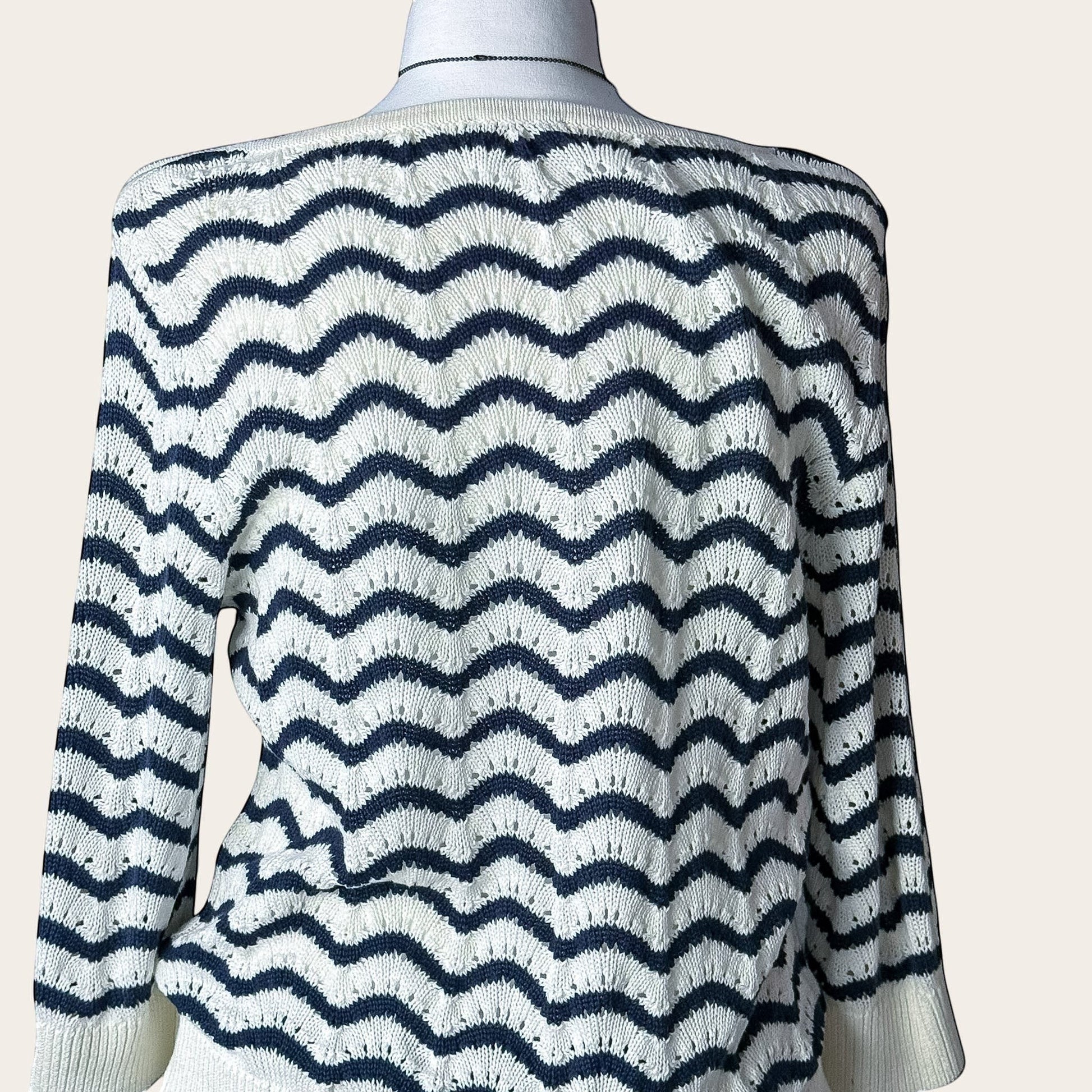 Damski sweter TrickandChic w biało-granatowe faliste paski z ażurowej dzianiny z rękawem 3/4 i dekoltem w łódkę.